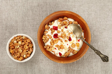 Close up portion of muesli granola breakfast with yogurt, fruits and berries, elevated top view,...
