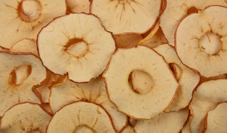 Close up many dried crispy apple ring chips on retail display, elevated top view, directly above