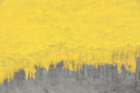 Old yellow painted gray plaster concrete wall with weatherstains, runs and defectsの写真素材