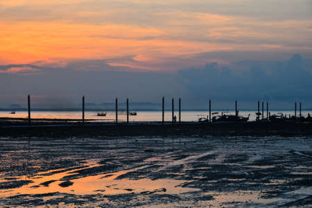 Beautiful sunrise scene over sea pier with sky reflection in water during low tide in Krabi, Thailandの写真素材