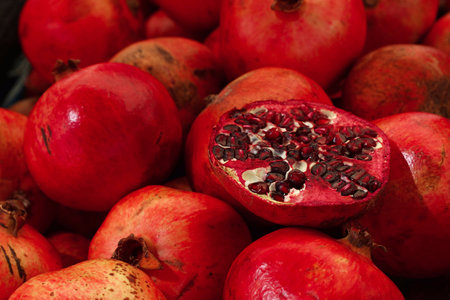 Close up fresh red ripe pomegranates at retail market stall display, high angle viewの写真素材