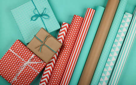 Close up packing and wrapping gifts with red, blue and brown paper, table top view, flat layの写真素材