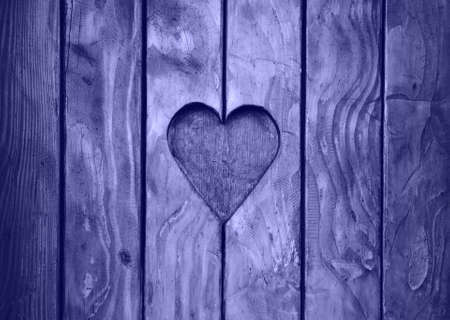Close up one heart shape, symbol of love and romance, wood carved in wooden window shutter, toned in lavender, very peri, color of year 2022の写真素材