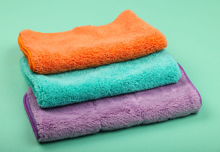 Stack of everal new soft colorful microfiber clothes and mops for household cleaning, high angle...