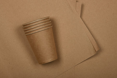 Close up disposable paper takeaway coffee cups on brown paper background, close up, elevated table top view, directly aboveの写真素材