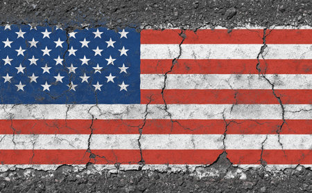 Grunge damaged weathered national flag of USA over broken cracked concrete background, symbol of American patriotismの写真素材