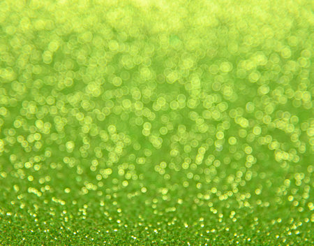 Abstract background of green bokeh defocused blurred lights and glitter sparklesの写真素材