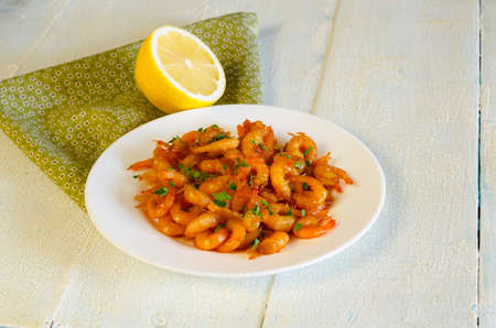 GRILLED HONEY GARLIC SHRIMP AT PLATE ON WOODEN TABLEの写真素材