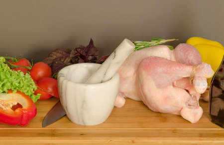 Row chicken with vegetables and spice on wooden tableの写真素材
