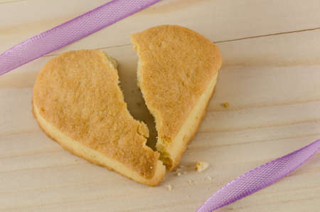 Broken heart cookies on wooden backgroundの写真素材