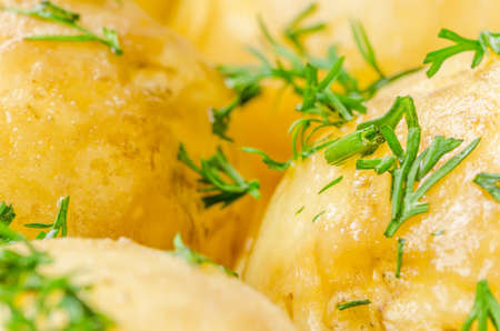 Traditional Ukrainian food boiled new potatoes with butter and dill on wooden tableの写真素材