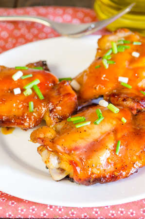 HONEY SOY CHICKEN GRILLED THIGHS AT WOODEN TABLEの写真素材