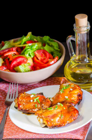 HONEY SOY CHICKEN GRILLED THIGHS AT WOODEN TABLEの写真素材