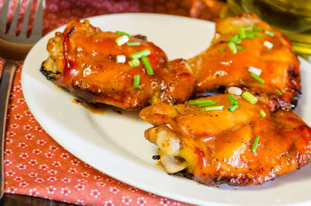 HONEY SOY CHICKEN GRILLED THIGHS AT WOODEN TABLEの写真素材