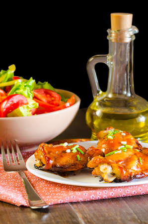 HONEY SOY CHICKEN GRILLED THIGHS AT WOODEN TABLEの写真素材