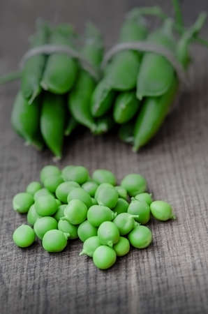Green organic peas on wooden background, shalow focusの写真素材