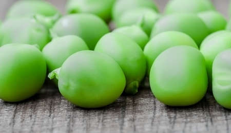 Green organic peas on wooden background, shalow focusの写真素材