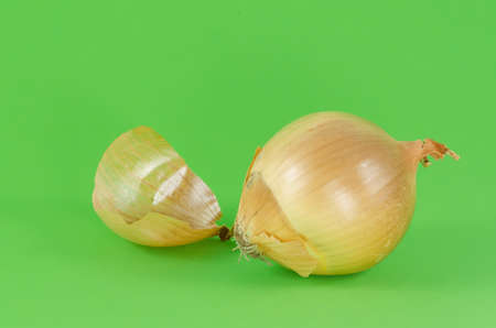 Ripe unpeeled onion on green background close upの写真素材