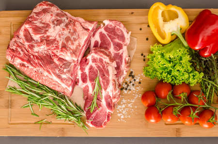Raw meat with vegetables and spices on wooden backgroundの写真素材