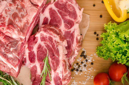 Raw meat with vegetables and spices on wooden backgroundの写真素材