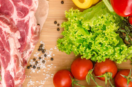 Raw meat with vegetables and spices on wooden backgroundの写真素材