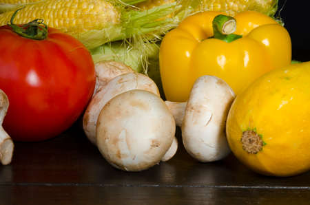 Ripe organic vegetables on wooden table at dark background still lifeの写真素材