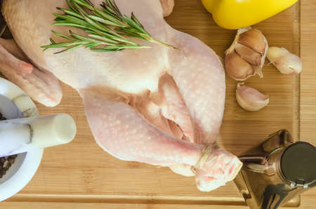 Row chicken with vegetables and spice on wooden backgroundの写真素材