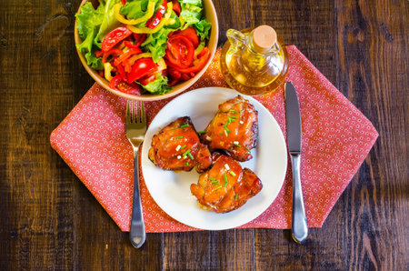 HONEY SOY CHICKEN GRILLED THIGHS AT WOODEN TABLEの写真素材