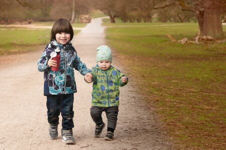 Two little boy going by road and handling handsの写真素材