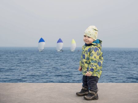 Small boy at seaside watching the regattaの写真素材