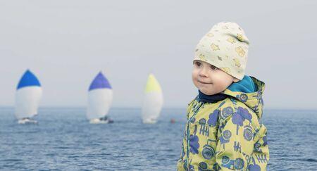 Small boy at seaside watching the regattaの写真素材