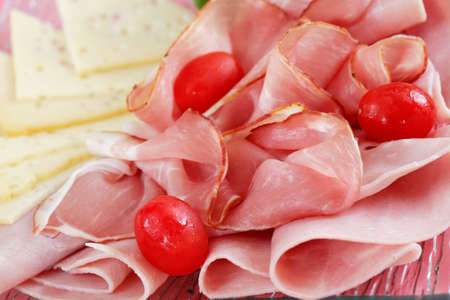 Sliced ham on plate in red toneの写真素材