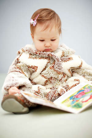 Small baby reading a bookの写真素材