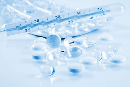 Pills and thermometer in blue toneの写真素材
