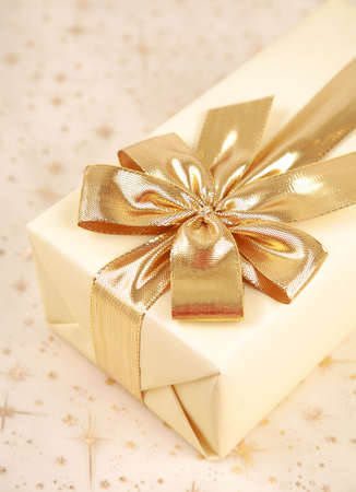Christmas present with bow in golden toneの写真素材
