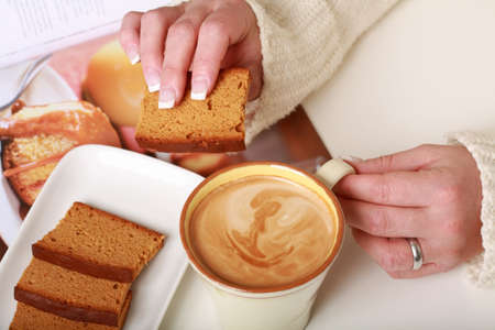 Woman hands with cup of milf coffee with biscuitの写真素材