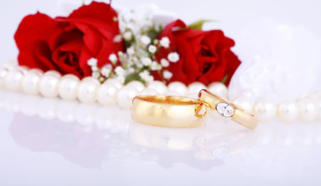 Still life with golden wedding rings and red rosesの写真素材