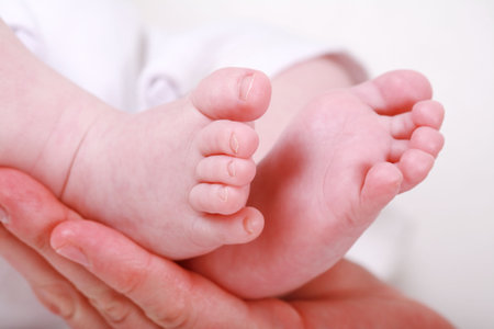 Detail of newborn's feet in mother's hands - shallow DOF