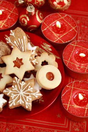 Detail of delicious Christmas cookies with candles in red toneの写真素材