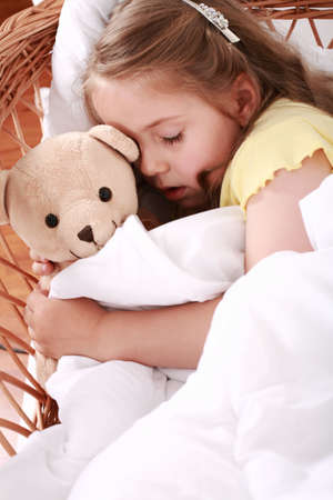 Portrait of cute little girl sleeping with teddyの写真素材