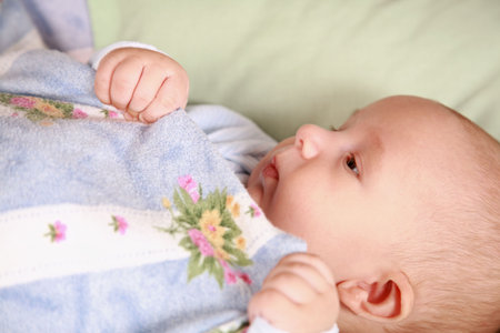 Portrait of adorable baby lying in bed