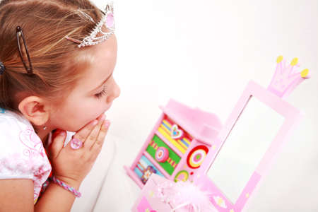 Beautiful small girl looking at the mirrorの写真素材