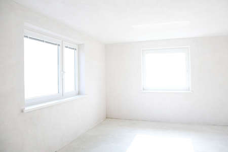 Moving in or out - empty room with two windowsの写真素材