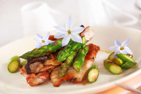 Gourmet steak with shiitake mushrooms and asparagus decorated with eatable flowersの写真素材