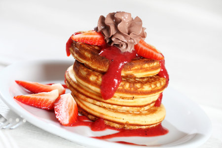Sweet pancakes with strawberry sauce and chocolate creamの写真素材