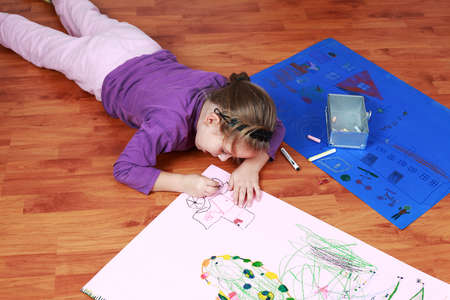 Cute little girl painting on the floorの写真素材