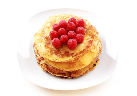Sweet pancakes with fresh raspberries on white background