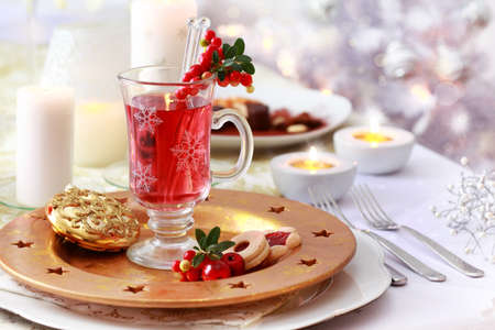 Hot wine cranberry punch for winter and Christmas and Christmas tree in backgroundの写真素材