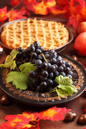 Red grapes and apple pie for Thanksgivingの写真素材