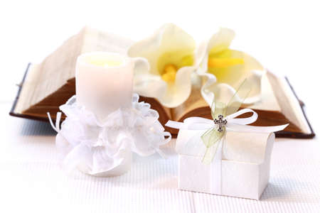 First holy communion or confirmation - candle, open bible and small presentの写真素材